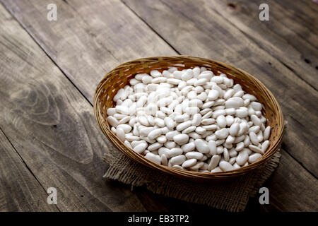 wicker basket full of beans on table, food closeup Stock Photo