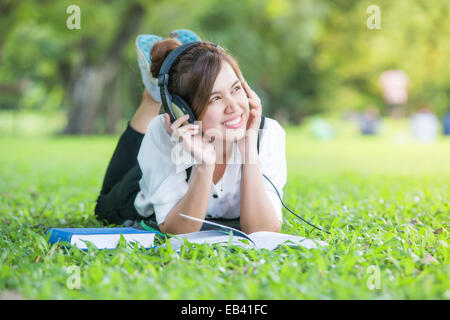 Asian student with Headphones Outdoors. Enjoying Music Stock Photo