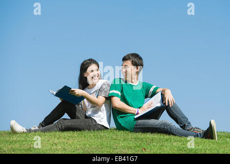 Couple of Asian students outdoors looking very happy Stock Photo