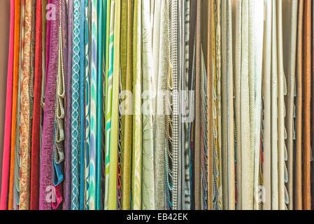 Colorful curtain samples hanging from hangers on a rail in a display in a retail store Stock Photo