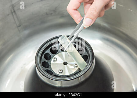 Scientist loading a sample to centrifuge Stock Photo