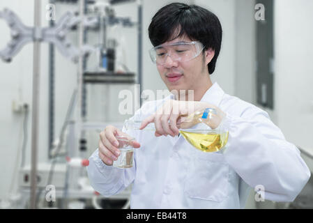 Scientist filling an Erlenmeyer flask in a chemical laboratory