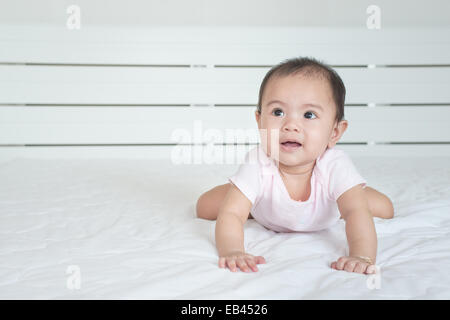 cute crawling baby girl in bedroom Stock Photo