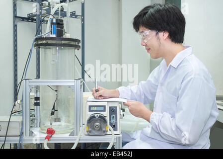 Scientist conducting research taking notes  in laboratory Stock Photo
