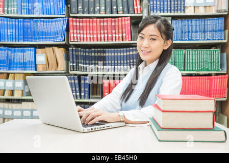 Asian student using laptop computer in university library Stock Photo
