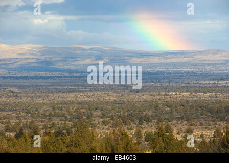 Rainbow over juniper woodland, Lava Beds National Monument, California Stock Photo
