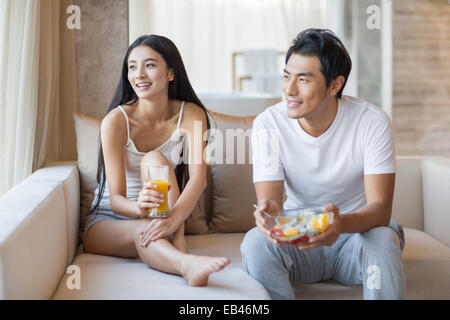 Happy young couple sitting on the sofa Stock Photo
