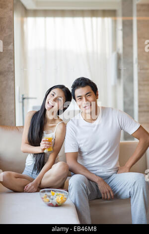 Happy young couple sitting on the sofa Stock Photo