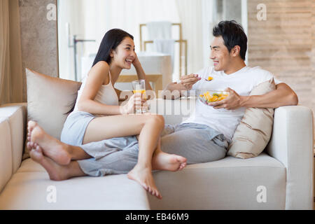 Happy young couple sitting on the sofa Stock Photo