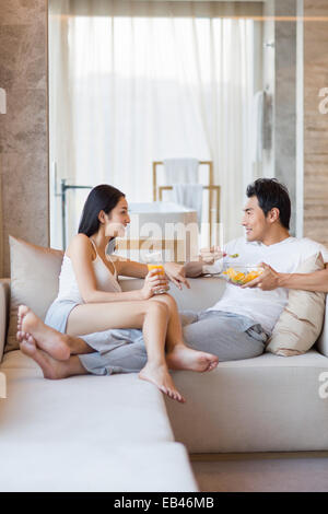 Happy young couple sitting on the sofa Stock Photo