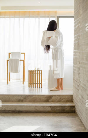 Young woman drying her hair with a towel in bathroom Stock Photo