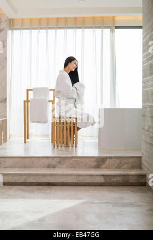 Young woman drying her hair with a towel in bathroom Stock Photo