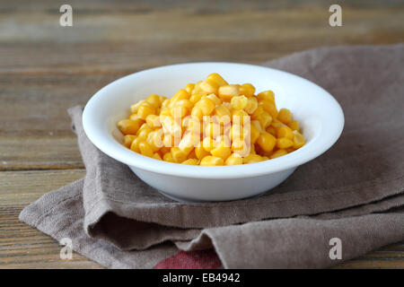 Canned sweet corn in a bowl, food on a wooden background Stock Photo