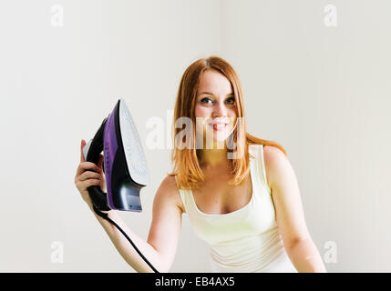 Happy young beautiful woman ironing clothes. Housework Stock Photo