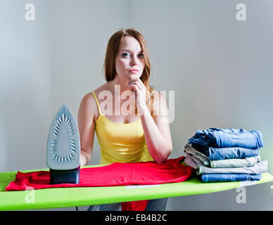 thoughtful woman of doing the ironing. Housework Stock Photo