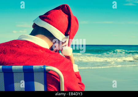 santa claus taking a nap in a beach chair on the beach Stock Photo