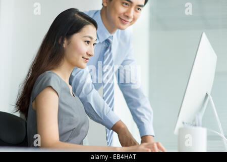 Young businesswoman and businessman talking in office Stock Photo
