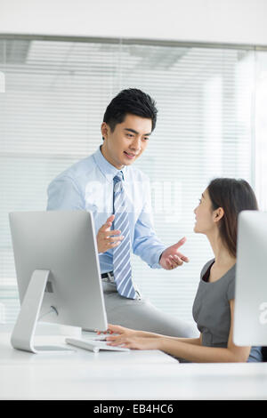 Young businesswoman and businessman talking in office Stock Photo