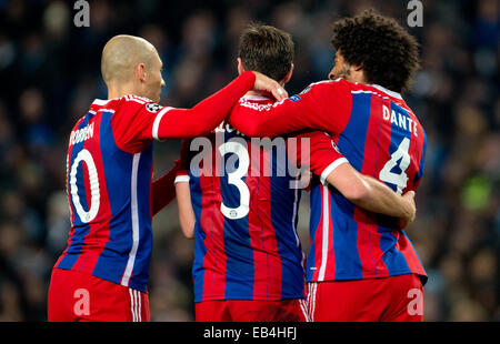 Manchester, UK. 25th Nov, 2014. Munich's Xabi Alonso (C) celebrates after scoring the 1-1 with teammates Dante (R) and Arjen Robben during the UEFA Champions League Group E soccer match between Manchester City FC and Bayern Munich at Etihad Stadium in Manchester, Great Britain, 25 November 2014. Credit:  dpa picture alliance/Alamy Live News Stock Photo