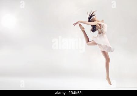 Pretty female ballet dancer in hard jump figure Stock Photo