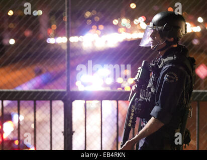 Los Angeles, California, USA. 25th Nov, 2014. An LAPD Tactical officer from Metro Division in full riot gear could be seen standing on the Grand Avenue 101 overpass on Tuesday as California Highway Patrol officers cleared the 101 freeway of debris and protesters.--- Tuesday night saw continued protests in Los Angeles as demonstrators rallied against the Ferguson Grand Jury and their decision not to indict officer Darren Wilson in the aftermath of his involvement in shooting Michael Brown in early August of this year. Credit:  David Bro/ZUMA Wire/Alamy Live News Stock Photo