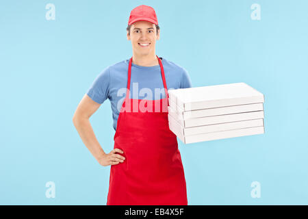 Pizza chef holding a bunch of boxes on blue background Stock Photo