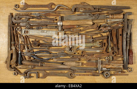 Various old and rusty tools, spread out on a wooden table. Stock Photo