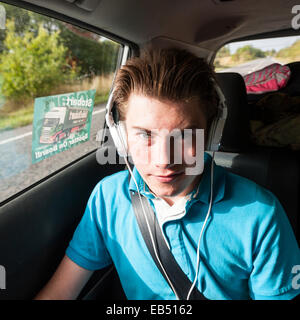 A 14 year old boy listening to music in the car Stock Photo