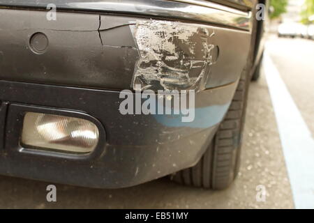 Close up on damaged front bumper of a car in the street Stock Photo