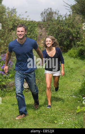 Cute couple running holding hands Stock Photo