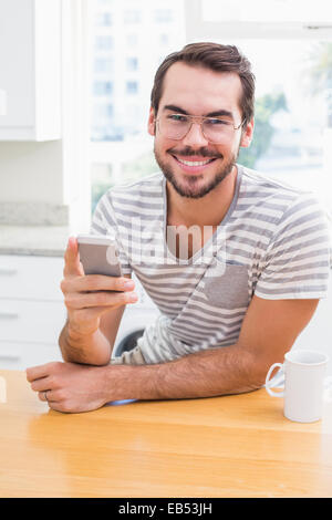 Young man using smartphone while having coffee Stock Photo
