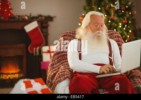 Santa claus typing on laptop Stock Photo