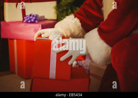 Santa Claus delivering presents to a house and taking gifts from his ...