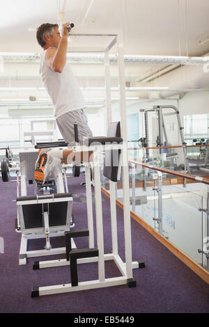 Fit man doing pull ups in fitness studio Stock Photo