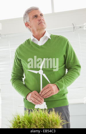 Casual businessman holding model wind turbine Stock Photo