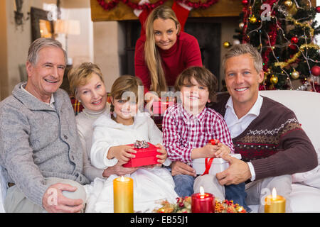 Multi generation family holding presents on sofa Stock Photo