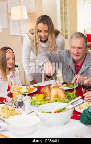 Grandfather carving chicken during christmas dinner Stock Photo