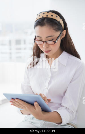 Businesswoman sitting and using tablet Stock Photo