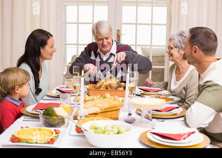 Grandfather carving chicken during christmas dinner Stock Photo