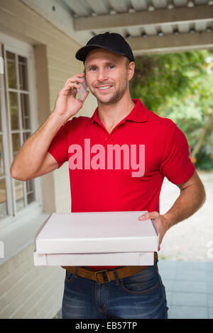 Happy pizza delivery man on the phone Stock Photo