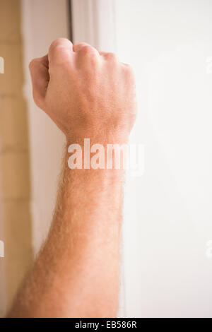 Hand knocking at the door Stock Photo