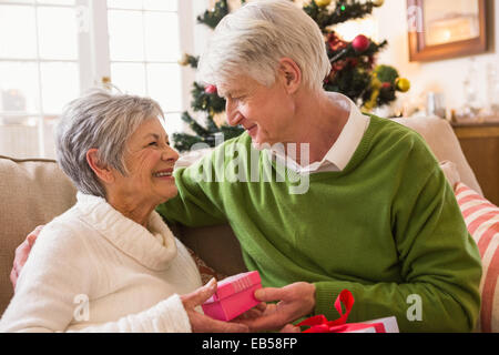Senior couple exchanging christmas gifts Stock Photo