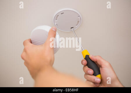 Handyman installing smoke detector Stock Photo