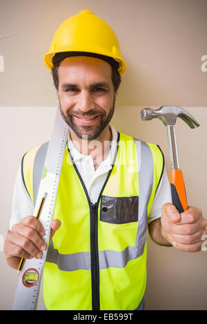Construction worker holding spirit level and hammer Stock Photo