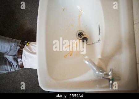 Plumber fixing the sink in a bathroom Stock Photo