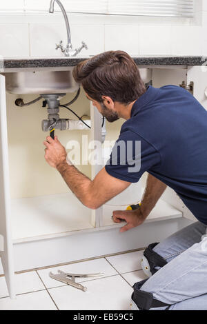 Plumber fixing under the sink Stock Photo