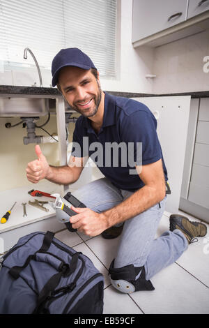Plumber fixing under the sink Stock Photo