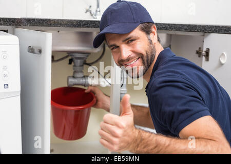 Plumber fixing under the sink Stock Photo