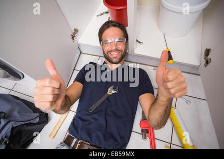 Plumber fixing under the sink Stock Photo