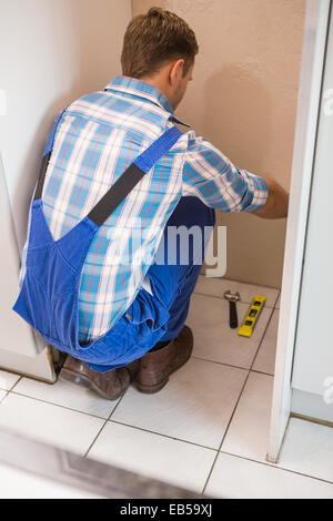 Builder fixing tiles on the floor Stock Photo